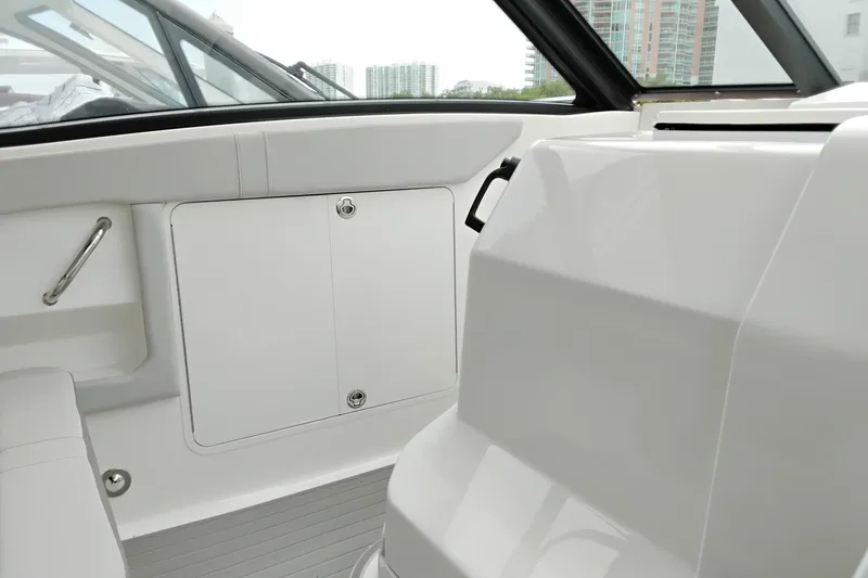 Slide: The Image of 2023 Sea Ray Sundancer 320 Outboard interior with sleek white seating and storage compartment. - 44