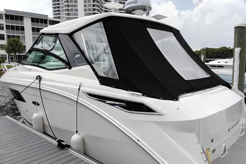 Slide: The Image of A 2023 Sea Ray Sundancer 320 Outboard docked, featuring a sleek black canopy. - 1