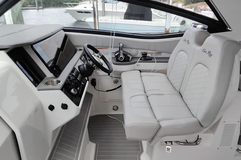 Slide: The Image of 2023 Sea Ray Sundancer 320 Outboard helm with modern controls and luxurious seating. - 9
