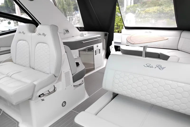Slide: The Image of 2023 Sea Ray Sundancer 320 Outboard interior with luxurious white seating and modern amenities. - 10