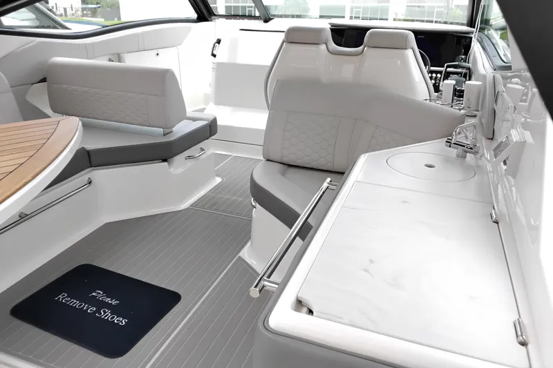 Slide: The Image of 2023 Sea Ray Sundancer 320 Outboard interior with seating, table, and sink. - 16
