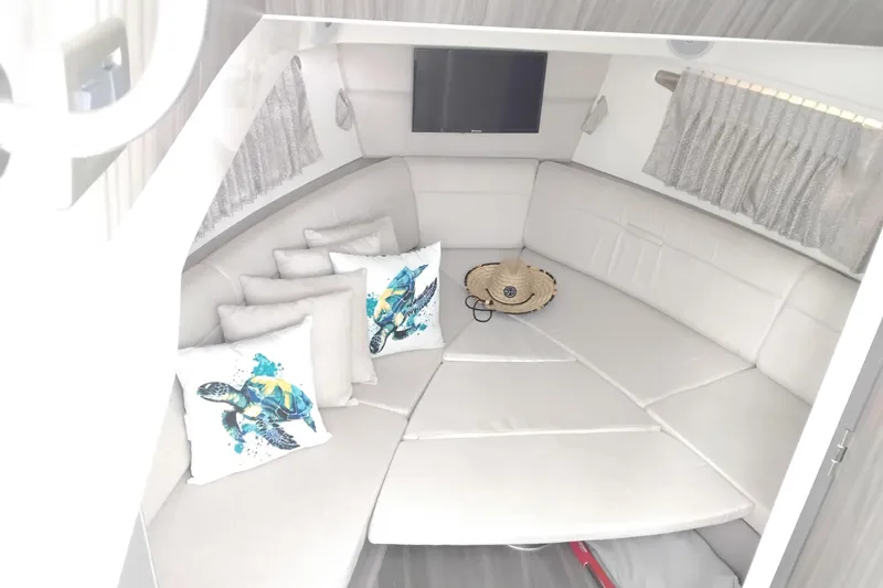 Slide: The Image of Interior of 2023 Sea Ray Sundancer 320 Outboard with plush seating and decorative pillows. - 35