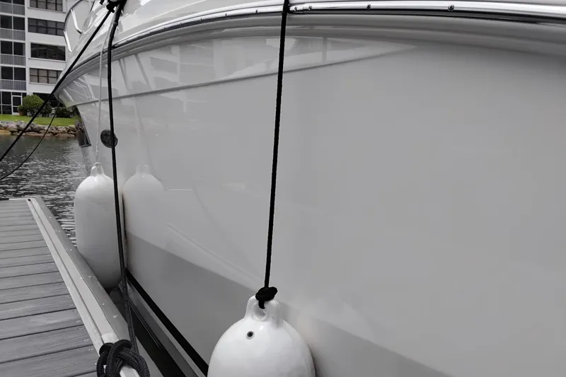 Slide: The Image of 2023 Sea Ray Sundancer 320 Outboard docked with fenders, side view. - 39