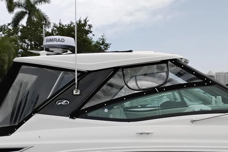 Slide: The Image of 2023 Sea Ray Sundancer 320 Outboard with Simrad radar, docked near palm trees. - 4