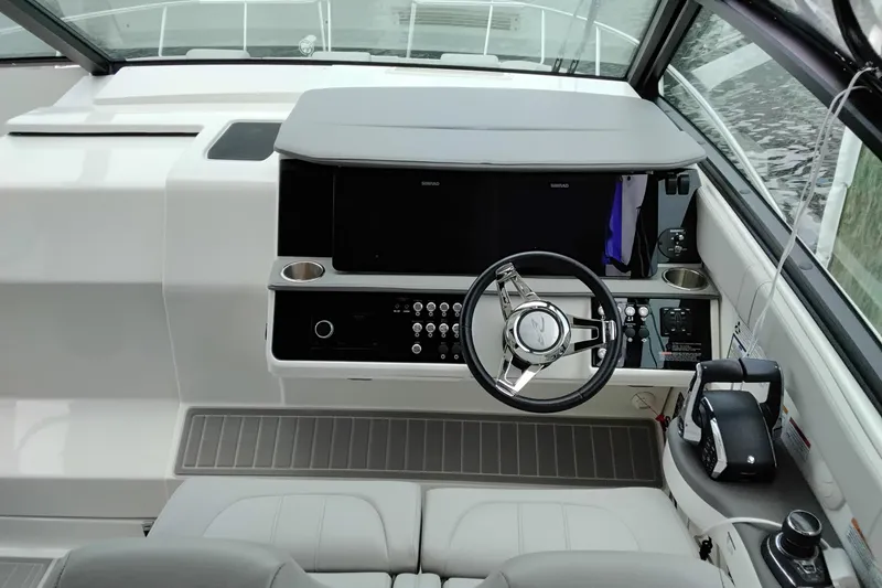 Slide: The Image of 2023 Sea Ray Sundancer 320 Outboard helm with modern controls and steering wheel. - 11