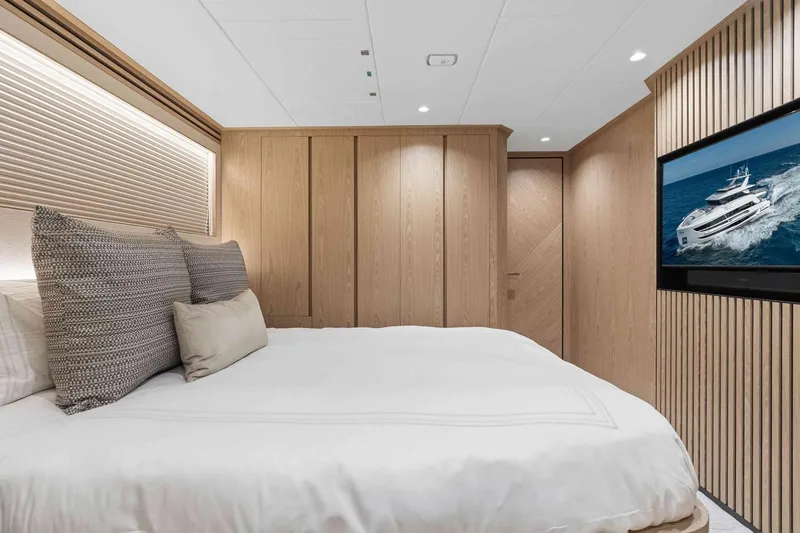 Slide: The Image of Luxurious bedroom interior on Horizon FD100 yacht, featuring modern wood paneling and a flat-screen TV. - 22