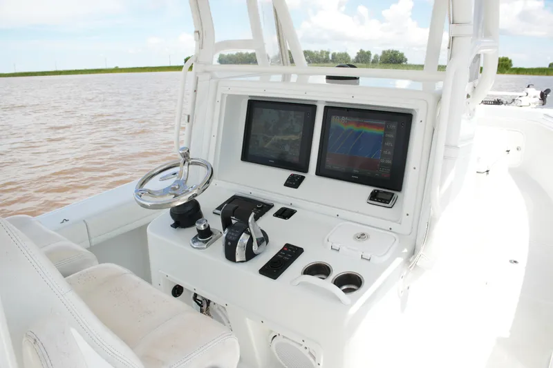 Slide: The Image of 2016 Yellowfin 32 Offshore boat dashboard with dual navigation screens and steering wheel. - 29