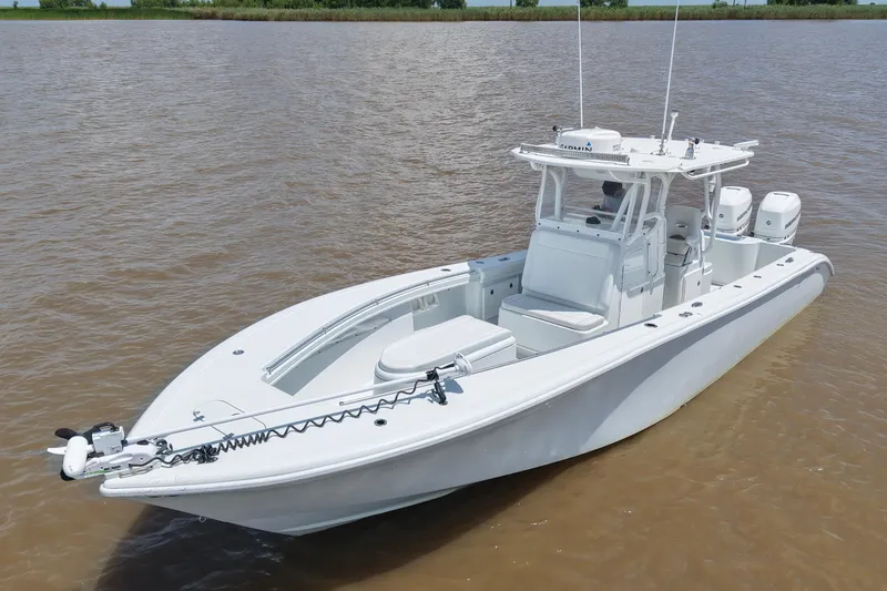 Slide: The Image of 2016 Yellowfin 32 Offshore boat on calm water, featuring dual engines and a sleek design. - 17