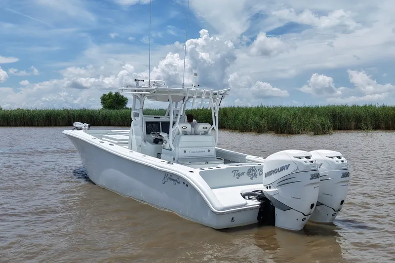 Slide: The Image of 2016 Yellowfin 32 Offshore boat with twin Mercury engines on a calm waterway. - 7