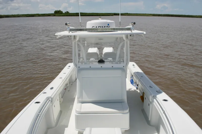 Slide: The Image of 2016 Yellowfin 32 Offshore boat on calm waters, featuring a spacious deck and modern design. - 25