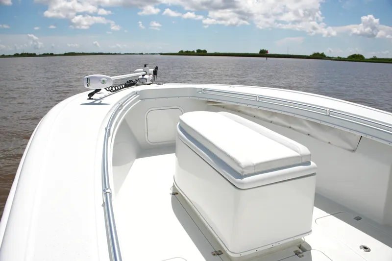 Slide: The Image of 2016 Yellowfin 32 Offshore boat interior with seating, on calm waters under a blue sky. - 21