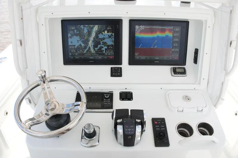 Slide: The Image of Helm of 2016 Yellowfin 32 Offshore boat with dual navigation screens and controls. - 36