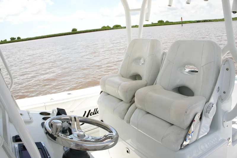 Slide: The Image of 2016 Yellowfin 32 Offshore boat interior with dual white seats and steering wheel. - 28