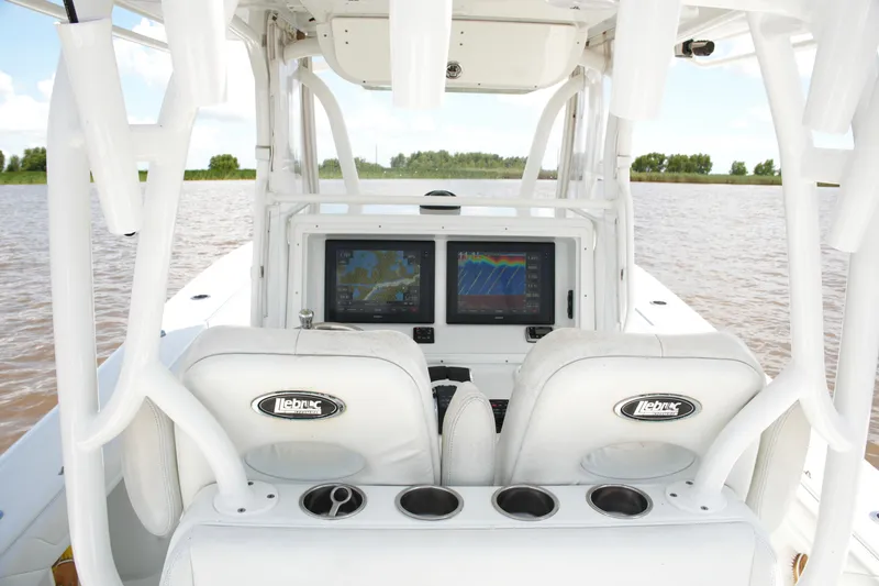 Slide: The Image of 2016 Yellowfin 32 Offshore boat cockpit with dual navigation screens on a calm water backdrop. - 35