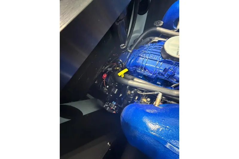 Slide: The Image of 2019 MasterCraft NXT22 engine compartment with blue components and visible wiring. - 22