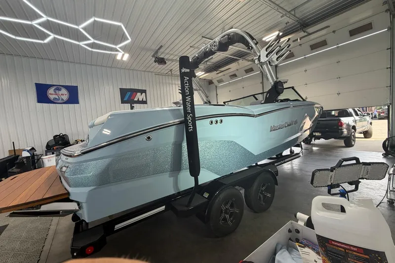 Slide: The Image of 2019 MasterCraft NXT22 boat in a garage, displayed on a trailer, with sleek design and modern features. - 14