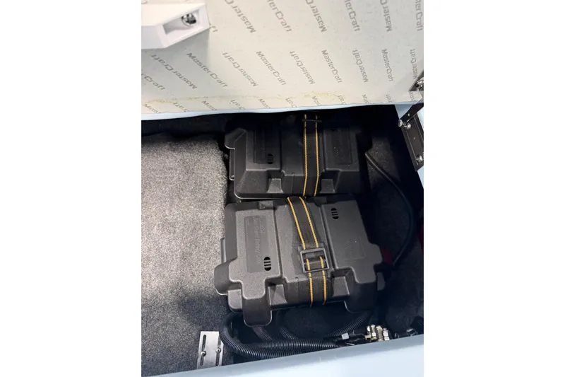 Slide: The Image of 2019 MasterCraft NXT22 boat battery compartment with secured dual batteries. - 26