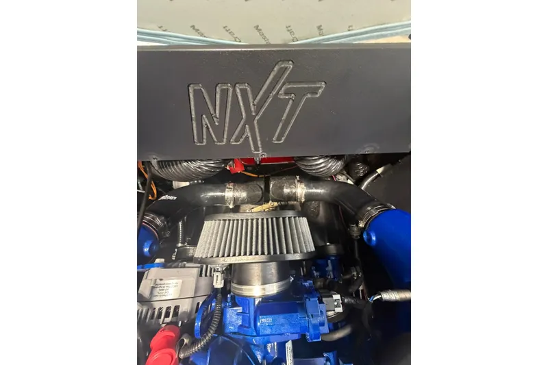 Slide: The Image of Engine compartment of 2019 MasterCraft NXT22 boat, showcasing mechanical components. - 19
