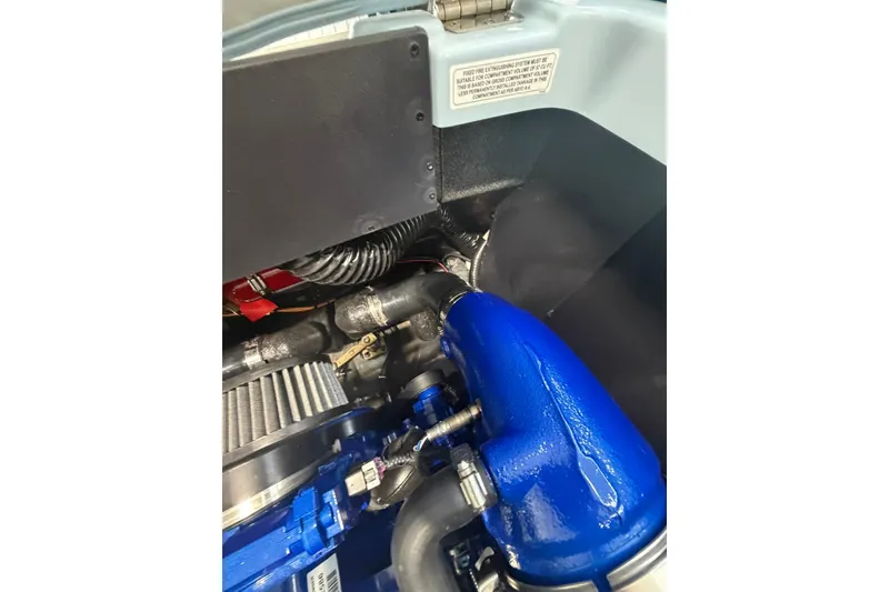 Slide: The Image of Engine compartment of a 2019 MasterCraft NXT22 boat, featuring blue components and wiring. - 20
