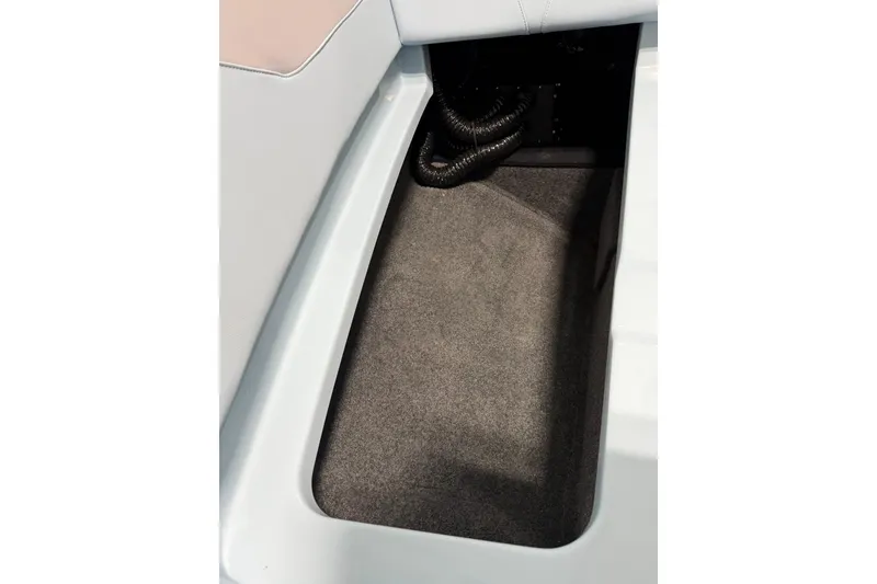Slide: The Image of Storage compartment in 2019 MasterCraft NXT22 boat, featuring carpeted interior and coiled cables. - 33
