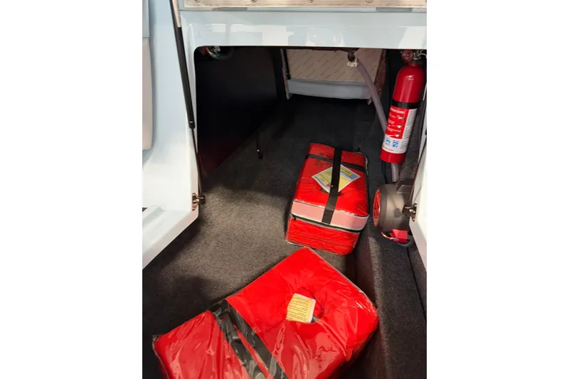 Slide: The Image of 2019 MasterCraft NXT22 interior storage with red safety equipment and fire extinguisher. - 27