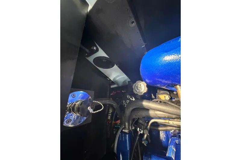 Slide: The Image of Engine compartment of 2019 MasterCraft NXT22 boat, featuring blue components and hoses. - 23