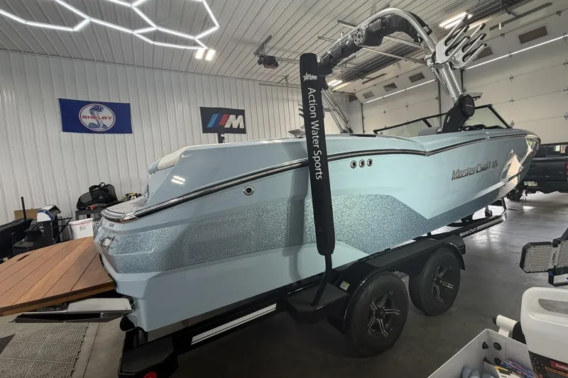 Slide: The Image of 2019 MasterCraft NXT22 boat in a garage, displayed on a trailer. - 13