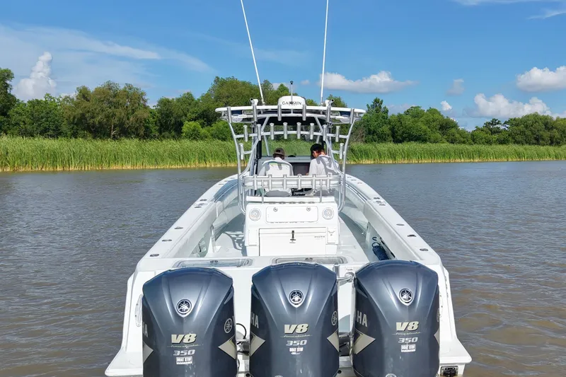 Slide: The Image of 2013 Contender 39 ST boat with triple Yamaha V8 engines on a calm river. - 7