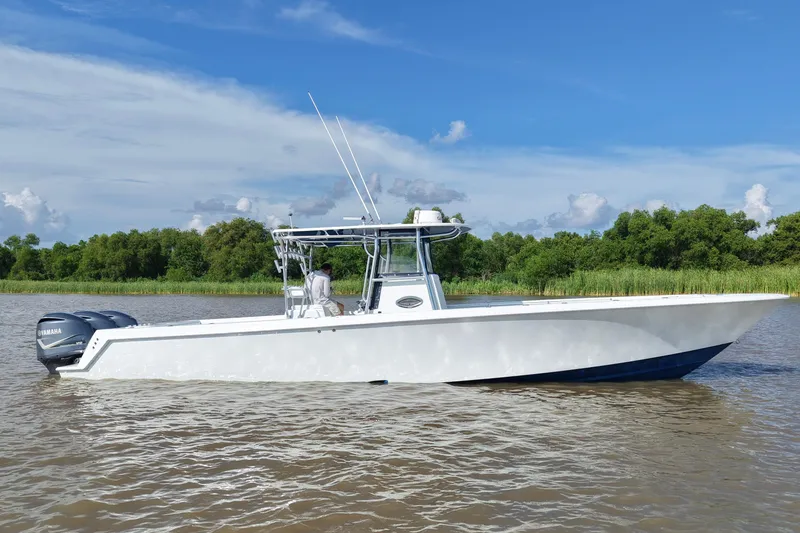 The Image of 2013 Contender 39 ST boat on calm water with Yamaha engines, under a clear blue sky. - 0