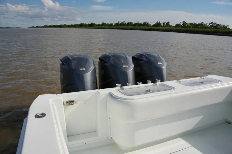 Slide: The Image of 2013 Contender 39 ST boat with triple V8 engines on a calm waterway. - 17