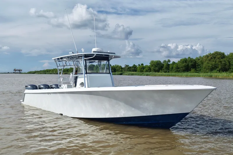 Slide: The Image of 2013 Contender 39 ST boat on calm water with lush green shoreline. - 4