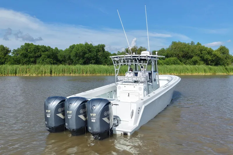 Slide: The Image of 2013 Contender 39 ST boat with triple Yamaha V8 engines on a calm river. - 5
