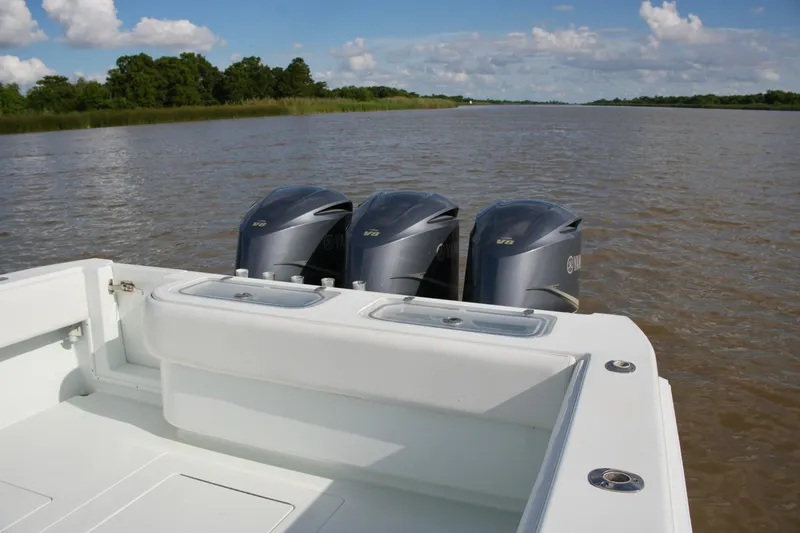 Slide: The Image of 2013 Contender 39 ST boat with triple Yamaha outboard engines on a calm river. - 19