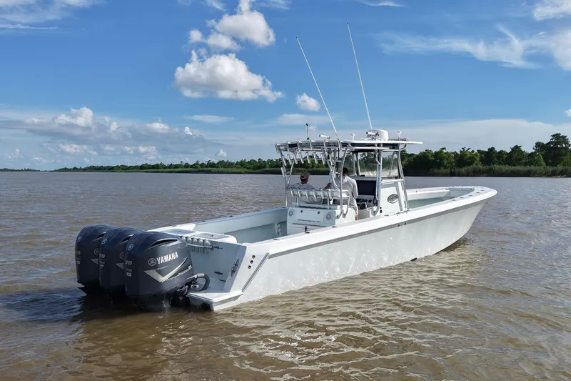 Slide: The Image of 2013 Contender 39 ST boat with triple Yamaha engines on a calm river. - 15