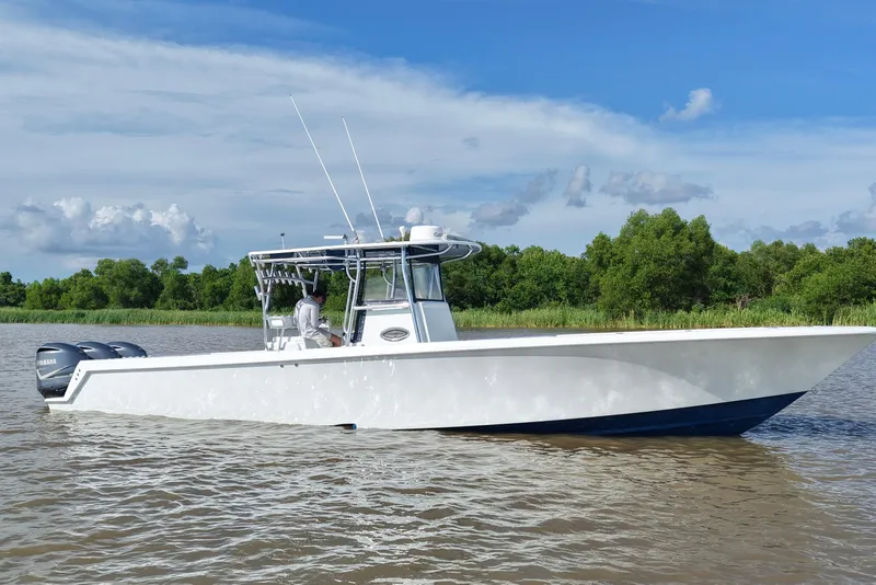 Slide: The Image of 2013 Contender 39 ST boat on calm water with lush green shoreline. - 3