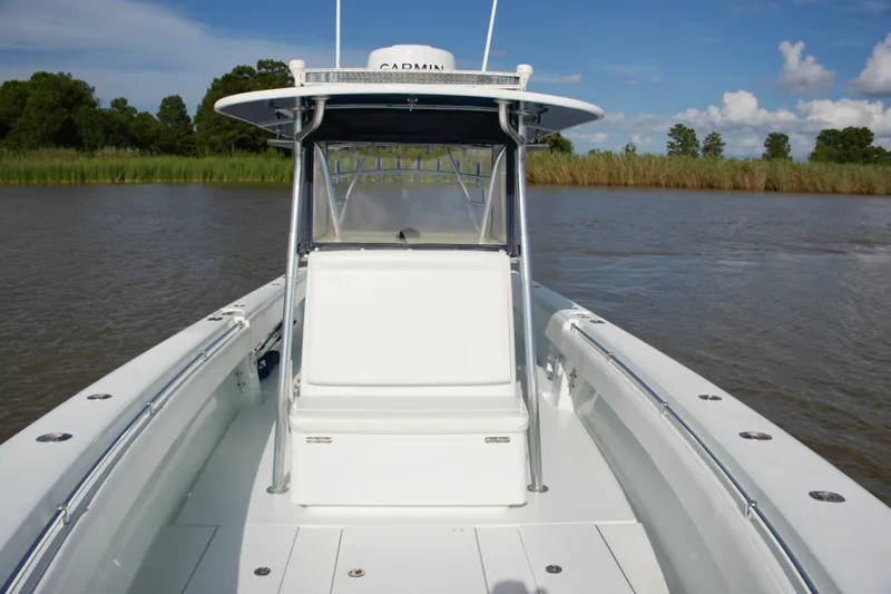 Slide: The Image of 2013 Contender 39 ST boat on calm water, featuring sleek design and spacious deck. - 25