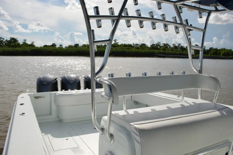 Slide: The Image of 2013 Contender 39 ST boat with triple engines on a sunny day, river backdrop. - 28