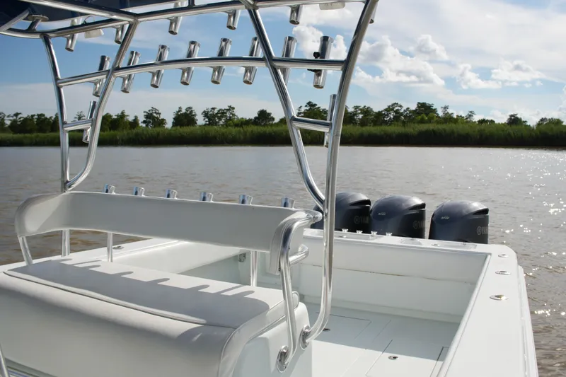 Slide: The Image of 2013 Contender 39 ST boat with multiple rod holders and Yamaha engines on a calm river. - 27