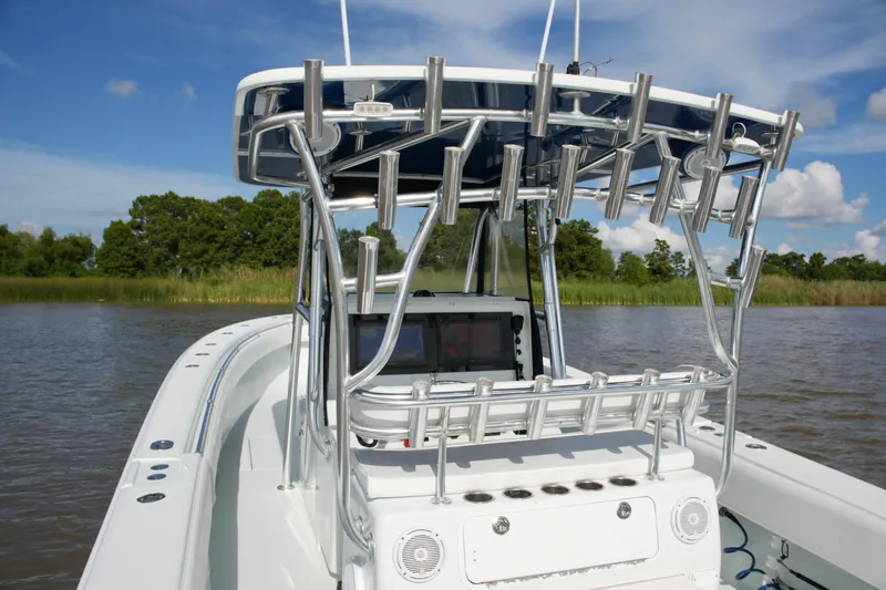 Slide: The Image of 2013 Contender 39 ST boat with rod holders, console, and clear sky background. - 36