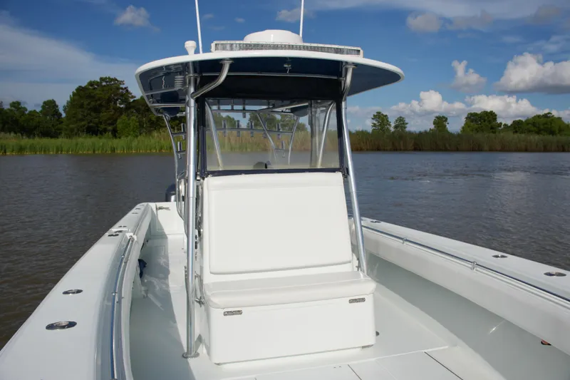 Slide: The Image of 2013 Contender 39 ST boat on calm water with lush greenery background. - 26