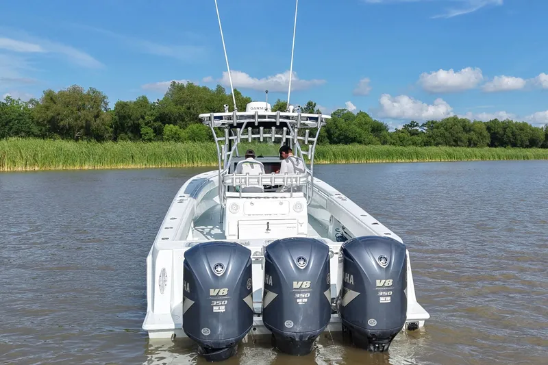 Slide: The Image of 2013 Contender 39 ST boat with triple Yamaha V8 engines on a calm river. - 6
