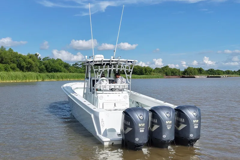 Slide: The Image of 2013 Contender 39 ST boat with triple Yamaha V8 engines on a calm river. - 8