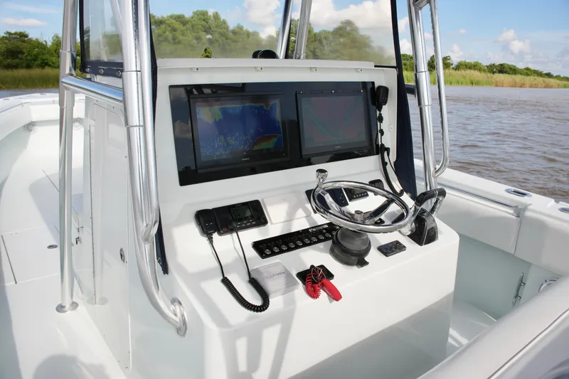 Slide: The Image of 2013 Contender 39 ST boat console with dual screens and steering wheel on a sunny day. - 29