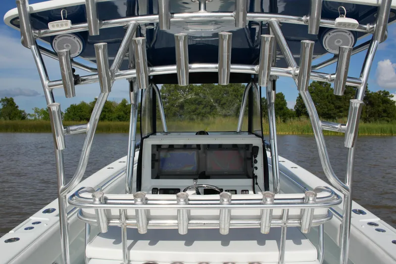 Slide: The Image of 2013 Contender 39 ST boat with rod holders and navigation equipment on a calm waterway. - 34
