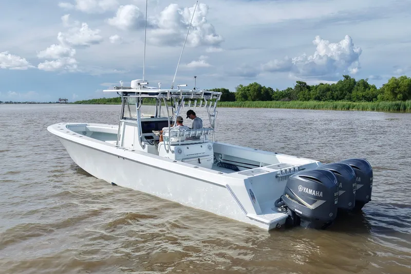 Slide: The Image of 2013 Contender 39 ST boat with triple Yamaha engines on a calm river. - 16