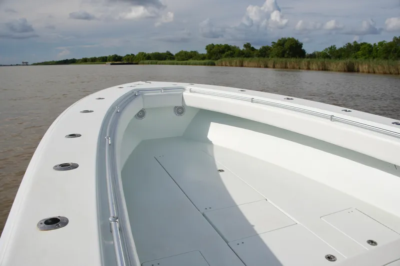 Slide: The Image of 2013 Contender 39 ST boat on calm water with lush green shoreline. - 22