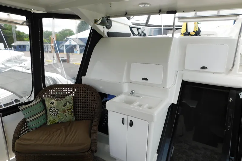 Slide: The Image of 1992 Silverton 41 Aft Cabin interior with wicker chair, cushions, and compact sink area. - 11