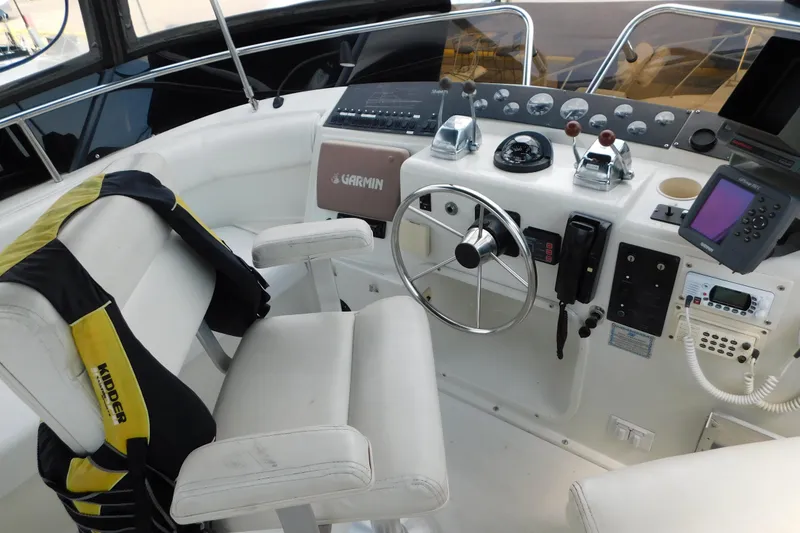Slide: The Image of 1992 Silverton 41 Aft Cabin helm with steering wheel, navigation equipment, and control panel. - 29