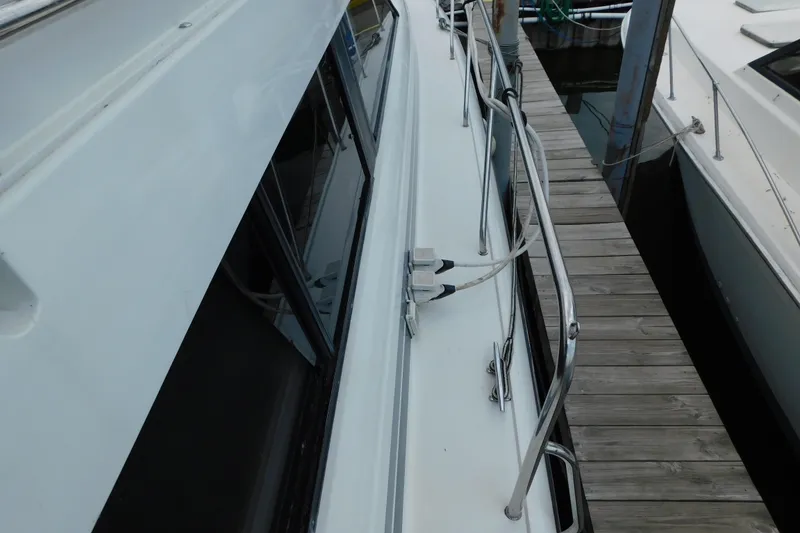 Slide: The Image of 1992 Silverton 41 Aft Cabin yacht docked, showing side deck and railing details. - 13