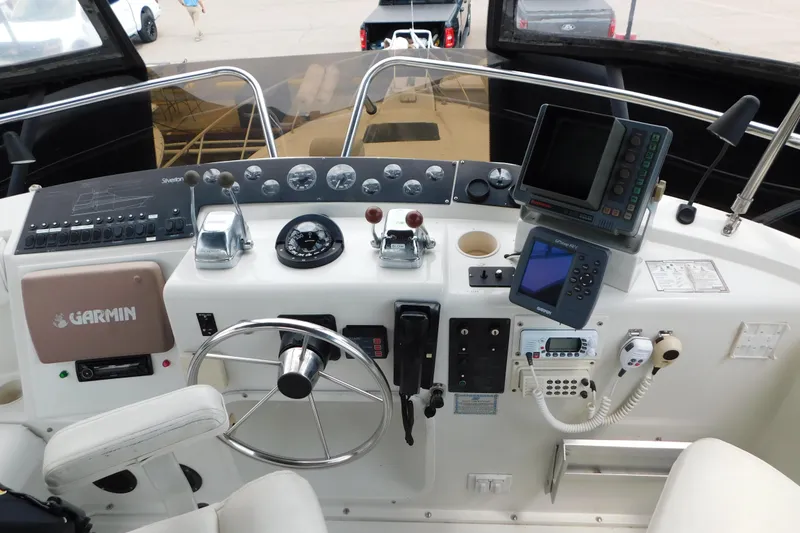 Slide: The Image of 1992 Silverton 41 Aft Cabin helm with Garmin navigation, steering wheel, and control panel. - 22